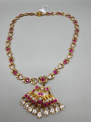 un collier en or orné de pierres roses et blanches