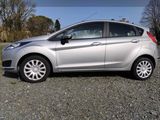 a silver car that is parked in the gravel