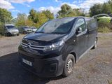 une camionnette noire garée sur un parking avec d'autres voitures