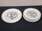 two plates with birds on them sitting on a table