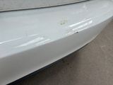 a white car that has some rust on the front of it
