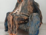 a sculpture of a man sitting on a chair