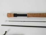 a close up of a fly rod and a fishing rod on a white surface
