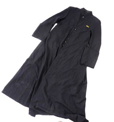 un trench-coat noir avec un empiècement jaune au niveau du col et des poignets
