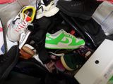 une valise pleine de chaussures et des chaussures sur le lit