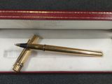 une image représentant un stylo dans une boîte rouge posée sur une table