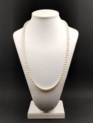 un mannequin blanc portant un collier de perles