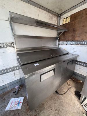 a metal work bench in the middle of a dirty room