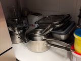 many pots and pans sitting on a shelf in the kitchen