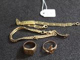 un bracelet en or, une bague et d'autres bijoux posés sur une table