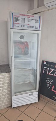 a pizza shop sign next to a pizza fridge