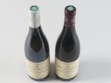 two bottles of wine sitting next to each other on a white surface
