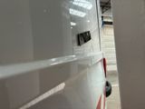 a white van with a red stripe parked inside of a building