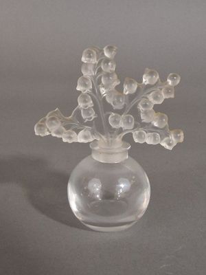 un vase en verre transparent contenant des fleurs, posé sur une table