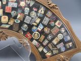 a fan with a lot of different badges on it