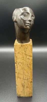 a close up of a statue of a woman ' s head on a wooden block