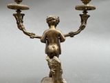 a bronze statue of a woman holding a candelabra