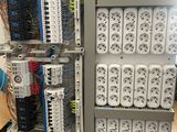 a rack of electrical equipment in a room with a fan