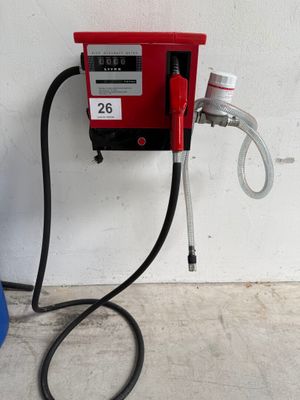 une pompe à essence rouge à laquelle est raccordé un tuyau