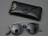 black sunglasses and a black case on a table with a pair of sunglasses