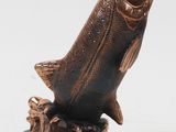 bronze fish sculpture on black base on white background