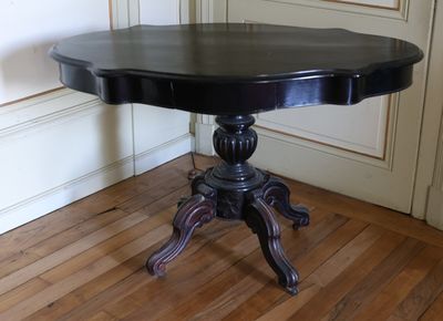 une table noire avec un plateau noir posée sur un sol en bois