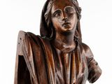 a close up of a wooden statue of a woman holding a shield