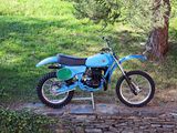 a blue dirt bike parked on the side of the road