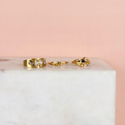 deux bagues en or posées sur un bloc de marbre, sur fond rose
