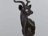 statue d'une antilope posée sur un socle en marbre, sur un fond blanc