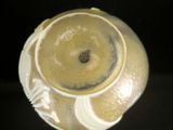 a close up of a yellow vase with a black background