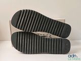the bottom of a pair of black and white slippers on a white surface