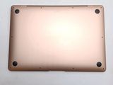 the back of a laptop with a gold cover on a white surface