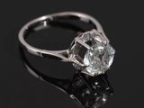 a close up of a diamond ring on a black surface
