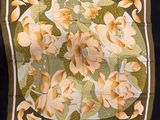 un gros plan d'un foulard carré orné de fleurs et de feuilles
