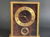 a clock that is sitting on a table with a black background
