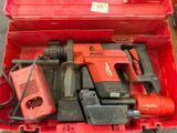 une boîte rouge posée par terre, contenant des outils