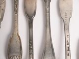a lot of spoons and forks on the table