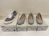 trois paires de chaussures grises et blanches posées sur des cartons