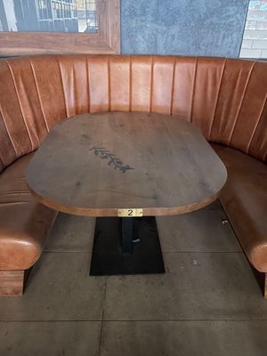 a wooden table with a wooden bench in the corner of a booth