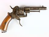 un vieux pistolet avec une poignée en bois sur une surface blanche