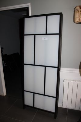 une grande armoire noire et blanche dans un coin de la pièce