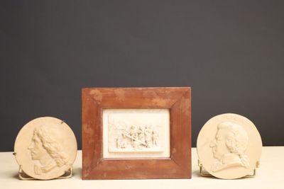 trois œuvres d'art posées sur une table, avec une photo d'un homme et d'une femme