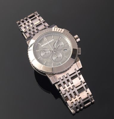 silver watch sitting on a black surface with a black surface in the background