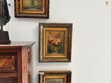 quatre tableaux accrochés au mur au-dessus d'une commode dans une pièce