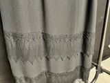 grey curtain with black lace on it hanging on a rack