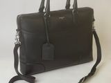 black leather briefcase with strap and tag on white background