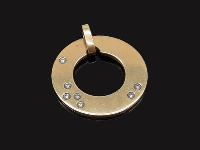 une image représentant un pendentif plaqué or serti de diamants sur fond noir