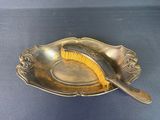 a silver plate with a brush in it on a blue surface