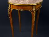 une petite table avec un plateau en marbre sur fond noir